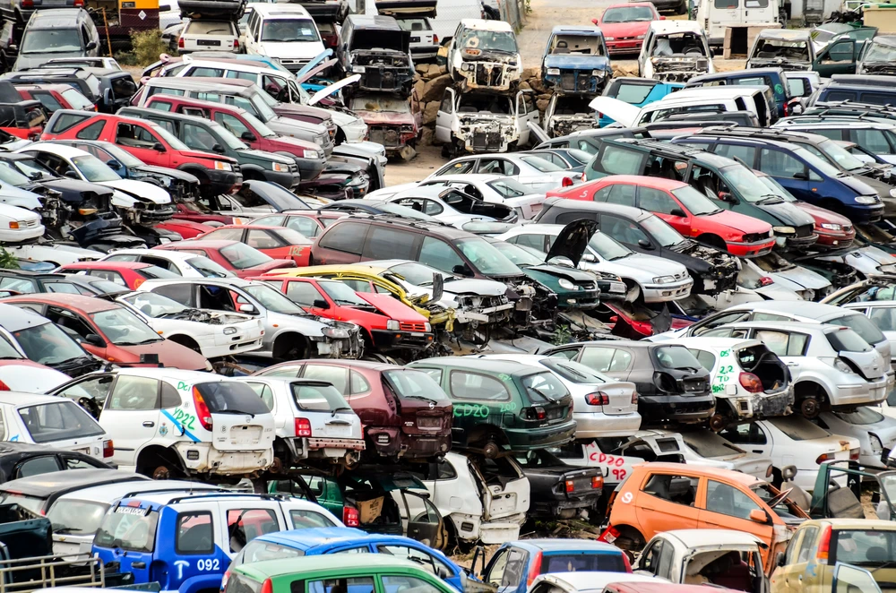 Casse automobile extérieure avec centaines de véhicules accidentés et épaves empilées